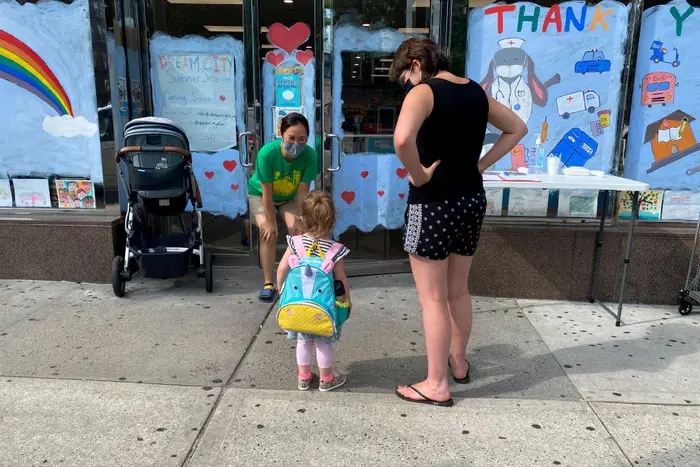 A parent drops off their child at a daycare in Queens.